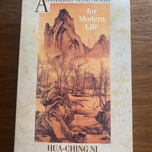 May include: A book titled "Ageless Counsel for Modern Life" with a landscape painting on the cover. The painting depicts mountains, trees, and a figure. The author's name, Hua-Ching Ni, and title, Teacher of Natural Spiritual Truth, are also visible.