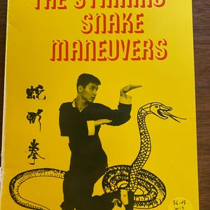 May include: A yellow book cover with the title "THE STRIKING SNAKE MANEUVERS" in red. The cover features a black illustration of a snake and a person in a martial arts pose. Chinese characters are also present.
