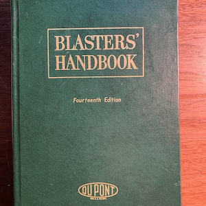 May include: A green hardcover book titled "Blasters' Handbook" with the text "Fourteenth Edition" and a gold "DuPont" logo.