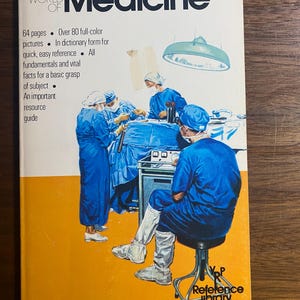 Puede incluir: Un libro antiguo titulado "The World of Medicine" con una portada amarilla y blanca. La portada presenta una ilustración de un equipo quirúrgico con batas azules. El libro incluye texto sobre el contenido y es de la serie Reference Library Books.