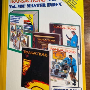 May include: A yellow and black cover of a book titled "The Omega Transactions and Vol. MM Master Index". The cover features a variety of images of industrial equipment and a man in a blue lab coat. The book is part of a series of handbooks and encyclopedias.