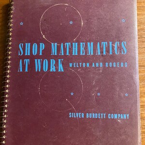 May include: A burgundy book with a spiral binding. The title is "Shop Mathematics at Work" by Welton and Rogers. The book is published by Silver Burdett Company.