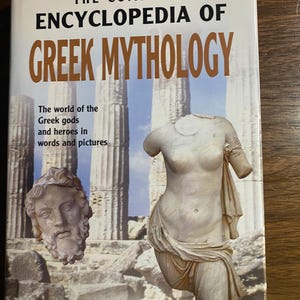 Puede incluir: Un libro titulado "The Complete Encyclopedia of Greek Mythology" con una portada que presenta una estatua y un busto. La portada también incluye el texto "El mundo de los dioses y héroes griegos en palabras e imágenes" y el nombre del autor, Guus Houtzager.