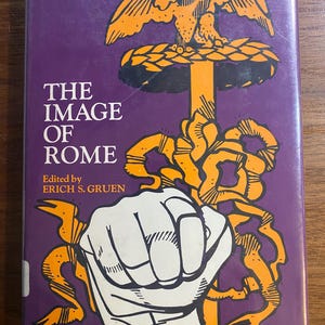 May include: A book titled "THE IMAGE OF ROME" with a purple cover. The cover features an orange illustration of an eagle, a sword, and a clenched fist. The book is edited by Erich S. Gruen.