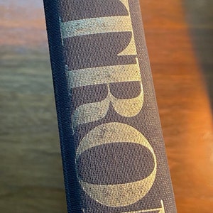 Op de afbeelding: Close-up van de rug van een gebonden boek met de titel "Asimov's" in gouden letters op een donkerblauwe achtergrond.