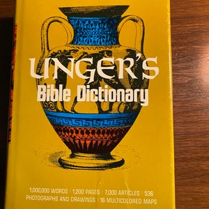 May include: A mustard yellow hardcover book titled "UNGER'S Bible Dictionary". The cover displays a detailed illustration of a Greek vase in black, blue, and red. The book's title is in large white letters. The book contains 1,000,000 words, 1,200 pages, and 7,000 articles.