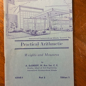 May include: A blue and white cover of a book titled "Practical Arithmetic: Weights and Measures" by A. DeGROOT, M. Am. Soc. C. E.  The book is part of a series published by International Correspondence Schools. The cover features a drawing of a building with a large awning and a flag.