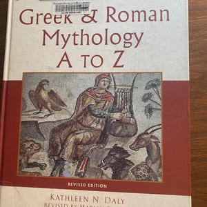May include: A hardcover book titled "Greek & Roman Mythology A to Z" with a mosaic-style illustration on the cover. The cover features a red border and the text "Revised Edition" and author information. The book has a library sticker.