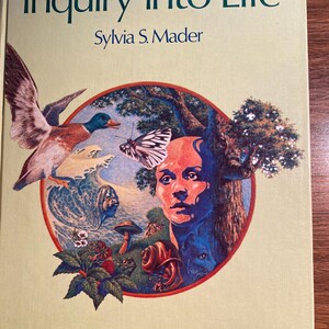 May include: A book titled "Inquiry into Life" by Sylvia S. Mader. The cover features a colorful illustration of a bird, a butterfly, a snail, a frog, a mushroom, and a human face.