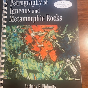 May include: A book titled "Petrography of Igneous and Metamorphic Rocks" by Anthony R. Philpotts. The book cover features a colorful abstract image of a rock sample with a white oval with the text "with accompanying CD-ROM".