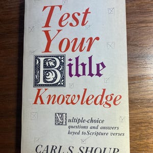 Puede incluir: Un libro antiguo titulado "Test Your Bible Knowledge" con letras rojas y moradas. La portada presenta elementos decorativos y el nombre del autor, Carl S. Shoup. El libro promete preguntas de opción múltiple y respuestas.
