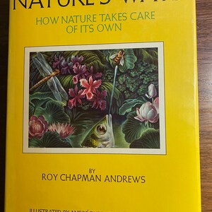 May include: A hardcover book titled "NATURE'S WAYS" with a bright yellow cover. The cover features the text "HOW NATURE TAKES CARE OF ITS OWN" and an illustration of a dragonfly, bee, fish, and flowers. The author is Roy Chapman Andrews.