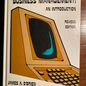 Puede incluir: Una portada de libro vintage con una ilustración amarilla y marrón de una computadora. El título es "Computers in Business Management: An Introduction, Revised Edition" por James A. O'Brien.