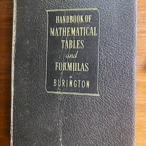 May include: A black hardback book titled Handbook of Mathematical Tables and Formulas by Burington. The cover features a textured, leather-like finish with gold-coloured lettering enclosed in a thin, rectangular border on the front cover.