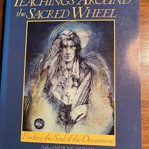 Pode incluir: Capa de livro com fundo azul e o título "Teachings Around the Sacred Wheel: Finding the Soul of the Dreamtime" de Lynn V. Andrews, autora de "Medicine Woman". A capa apresenta uma ilustração de uma mulher nativa americana com um lobo e uma coruja.