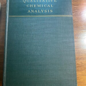 May include: A hardcover book titled "QUALITATIVE CHEMICAL ANALYSIS" in gold lettering on a dark teal cover. The book has a textured surface and a gold horizontal line separating the title from the rest of the cover.