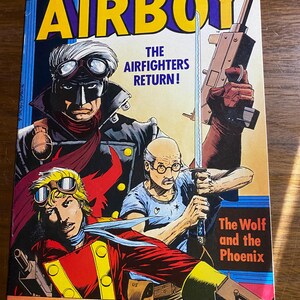May include: A vintage comic book cover titled "Airboy" featuring illustrations of several characters in aviator gear, holding weapons. The cover has a yellow, red, and blue color scheme, with text that reads "The Airfighters Return!" and "The Wolf and the Phoenix."