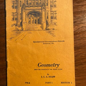 May include: A vintage book cover featuring a black and white illustration of a building with an arched entrance. The text on the cover reads "International Correspondence Schools Scranton, Pa. Geometry Prepared Especially for Home Study By I.C.S. Staff Part 1 Edition 1 778 A"