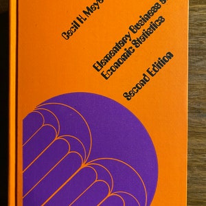 May include: Orange book cover with the title "Elementary Business and Economic Statistics" by Cecil H. Meyers, Second Edition. The cover features a purple design with a series of curved lines.
