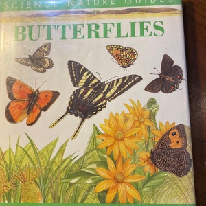 May include: A book titled "Butterflies" with a green and white cover featuring illustrations of butterflies and flowers. The book is part of a series called "Science Nature Guides". The text "More than 15 easy-to-do science projects" is printed at the bottom of the cover.