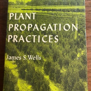 May include: A hardcover book titled Plant Propagation Practices by James S. Wells. The cover features a green-toned photograph of a large field of small evergreen shrubs arranged in rows, with a line of trees visible in the distant background.