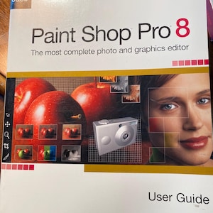 Puede incluir: Una guía del usuario para Paint Shop Pro 8, un software de edición de fotos y gráficos. La portada presenta un primer plano de la cara de una mujer y una cámara digital, con manzanas rojas y otros gráficos en el fondo.
