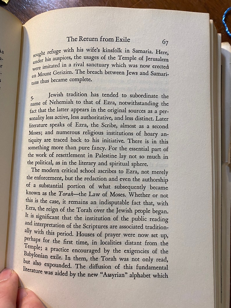 Op de afbeelding: Een pagina uit een boek getiteld "De Terugkeer uit Ballingschap" die de rol van Ezra in de Joodse geschiedenis bespreekt. De tekst beschrijft Ezra als een schriftgeleerde en bespreekt het belang van de Thora in de Joodse traditie.