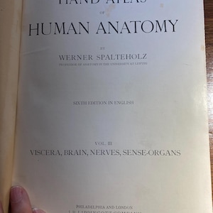 May include: Cover of a book titled "Hand-Atlas of Human Anatomy" by Werner Spalteholz, Professor of Anatomy in the University at Leipzig. The book is the sixth edition in English and is volume III, covering Viscera, Brain, Nerves, Sense-Organs. Published by J.B. Lippincott Company in Philadelphia and London.