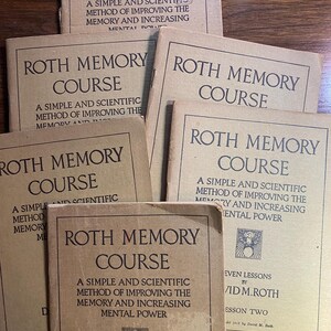Op de afbeelding: Een stapel van zes bruine, paperback boeken met de titel "Roth Memory Course". Elk boek heeft een andere ondertitel en auteur. Het bovenste boek heeft de ondertitel "Een eenvoudige en wetenschappelijke methode om het geheugen te verbeteren en de mentale kracht te vergroten". Het onderste boek heeft de ondertitel "Zeven lessen door David M. Roth".