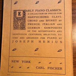 May include: A vintage music book cover with the title "Early Piano Classics: A Collection of Pieces for Harpsichord, Clavichord and Spinet by French, Italian and German Composers of the Seventeenth and Eighteenth Centuries, Selected, Edited and Arranged for Piano by Joseph Henius". The cover is brown with black text and a decorative border.