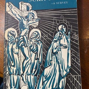 Puede incluir: Un libro azul titulado "The Holy Scriptures - A Survey" con una ilustración en blanco y negro de una escena de crucifixión en la portada. La ilustración representa a Jesús en la cruz con tres figuras de pie debajo.