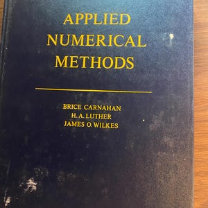 May include: A dark blue hardcover textbook titled Applied Numerical Methods in yellow text. The authors listed are Brice Carnahan, H. A. Luther, and James O. Wilkes. The book cover features a horizontal yellow line separating the title from the authors.