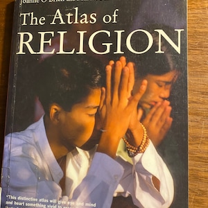 Pode incluir: A capa de um livro intitulado "The Atlas of Religion" de Joanne O'Brien e Martin Palmer. A capa apresenta uma fotografia de duas pessoas com as mãos juntas em oração. A citação "This distinctive atlas will give eye and mind and heart something vivid to grasp." de Martin E. Marty, professor emérito da Universidade de Chicago está impressa na parte inferior da capa.