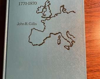 Könnte beinhalten: Ein blaues Buch mit dem Titel "The Development of European Society 1770-1870" von John R. Gillis. Der Umschlag zeigt eine schwarze Umrisskarte von Europa.