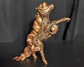 May include: A bronze-colored figurine of a mythical creature, possibly a horse or a griffin, with ornate detailing. The sculpture has a textured surface and stands on three legs, with its head and one arm raised.