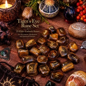Può includere: Un set di 25 pietre occhio di tigre levigate, ciascuna incisa con una runa Elder Futhark dorata. Il testo "Tiger's Eye Rune Set 25 Elder Futhark Runes for Divination, Meditation and Spiritual Practice" è stampato sulla superficie tra le pietre.