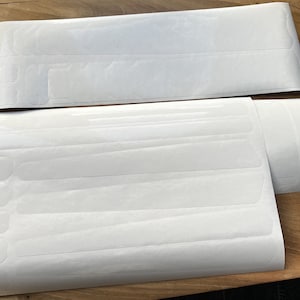 May include: A set of white adhesive strips for protecting bike frames. The strips are designed to be applied to the frame to prevent scratches and wear.