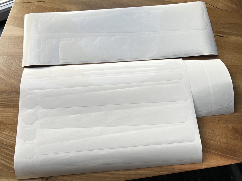May include: A set of white adhesive strips for protecting bike frames. The strips are designed to be applied to the frame to prevent scratches and wear.