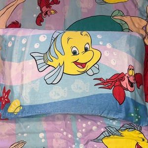 May include: A set of three ceramic mugs with a speckled, matte finish. The mugs are in shades of cream, light gray, and dark gray. Each mug has a simple, minimalist design and a rounded handle.