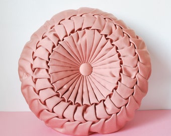 Beautiful pink round decorative cushion draped with two vintage sides