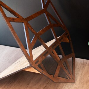 May include: A wooden geometric fox head sculpture with a brown stained finish. The sculpture is made of multiple pieces of wood that are joined together to create a three-dimensional design.