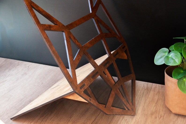 May include: A wooden geometric fox head sculpture with a brown stained finish. The sculpture is made of multiple pieces of wood that are joined together to create a three-dimensional design.