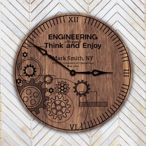 May include: A wooden clock with a brown background and black hands. The clock face has a design of gears and the text "ENGINEERING is like a puzzle Think and Enjoy Mark Smith, NY UCONN, University of Connecticut May, 2023".