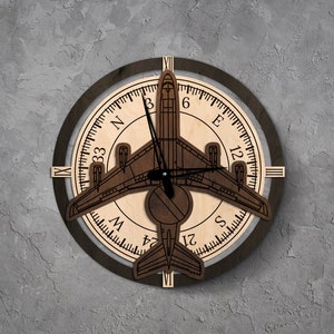 May include: A wooden clock with a plane design. The clock face has Roman numerals and a compass rose with the letters N, E, S, and W. The plane is in the center of the clock face and has a black hand.