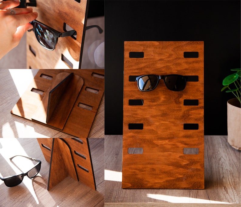 Puede incluir: Un expositor de gafas de sol de madera con un acabado marr&oacute;n intenso. El expositor tiene varias ranuras para sujetar gafas de sol, con un par de gafas de sol negras expuestas. El expositor es independiente y est&aacute; hecho de madera.
