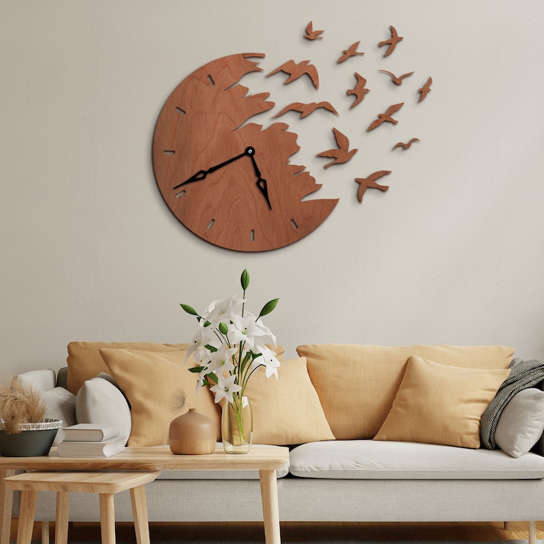 May include: A wooden wall clock with a unique design. The clock face is a circle with a portion cut away, and wooden birds are flying out from the cut-out section. The clock hands are black, and the wood has a warm, natural tone. The clock is mounted on a neutral-colored wall.