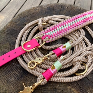 Può includere: Un guinzaglio per cani in corda beige con impugnatura intrecciata in rosa neon e verde chiaro, un cinturino per collare rosa acceso e finiture in metallo dorato, inclusi due moschettoni girevoli e diversi anelli a D per la regolazione.