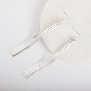 Peut inclure: Boucles d'oreilles en argent avec une longue chaîne en argent fine et une petite boucle en haut.