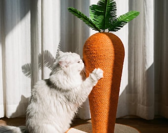 Könnte beinhalten: Ein karottenförmiger Kratzbaum für Katzen, umwickelt mit orangefarbenem Seil, mit einer runden Basis und grünen Kunststoffblättern an der Spitze. Eine langhaarige weiße Katze steht auf den Hinterbeinen und drückt ihre Vorderpfoten gegen die Oberfläche.