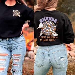 May include: Black sweatshirt with a graphic of ghosts and a disco ball. The text "Ghouls Just Wanna Have Fun!" is printed on the back of the shirt.